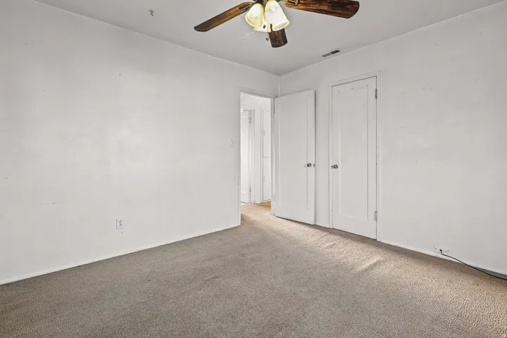 Neutral wall paint, ceiling fan with integrated lighting, and two panel doors
