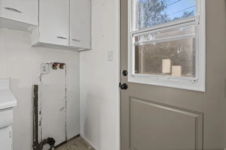 Built-in cabinetry, utility hookups, and a paneled entry door with an integrated window