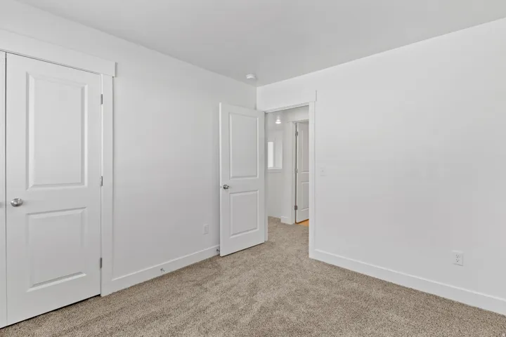 Interior room featuring light-colored carpet flooring and white walls
