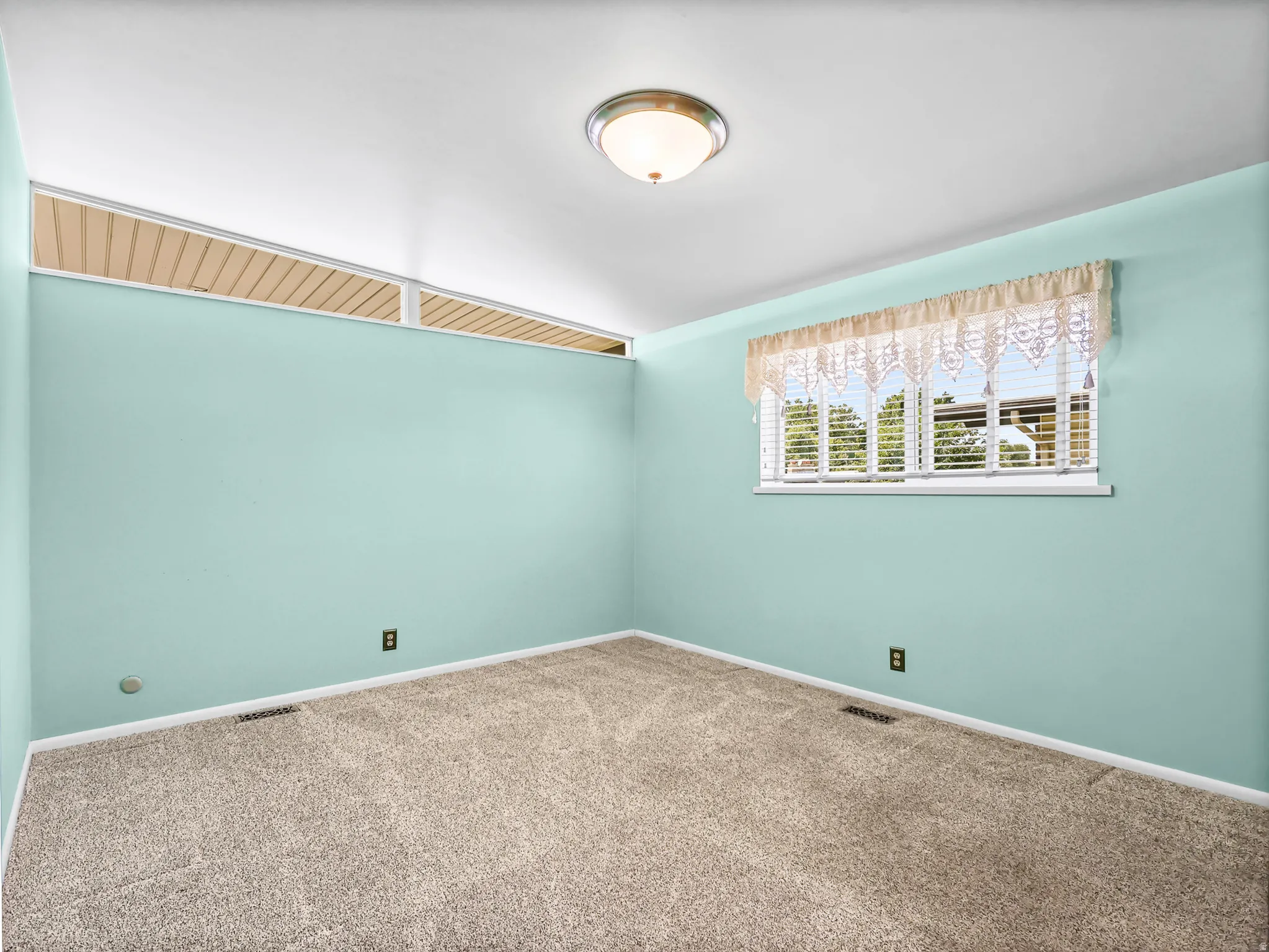 Room featuring light turquoise walls and neutral carpet flooring