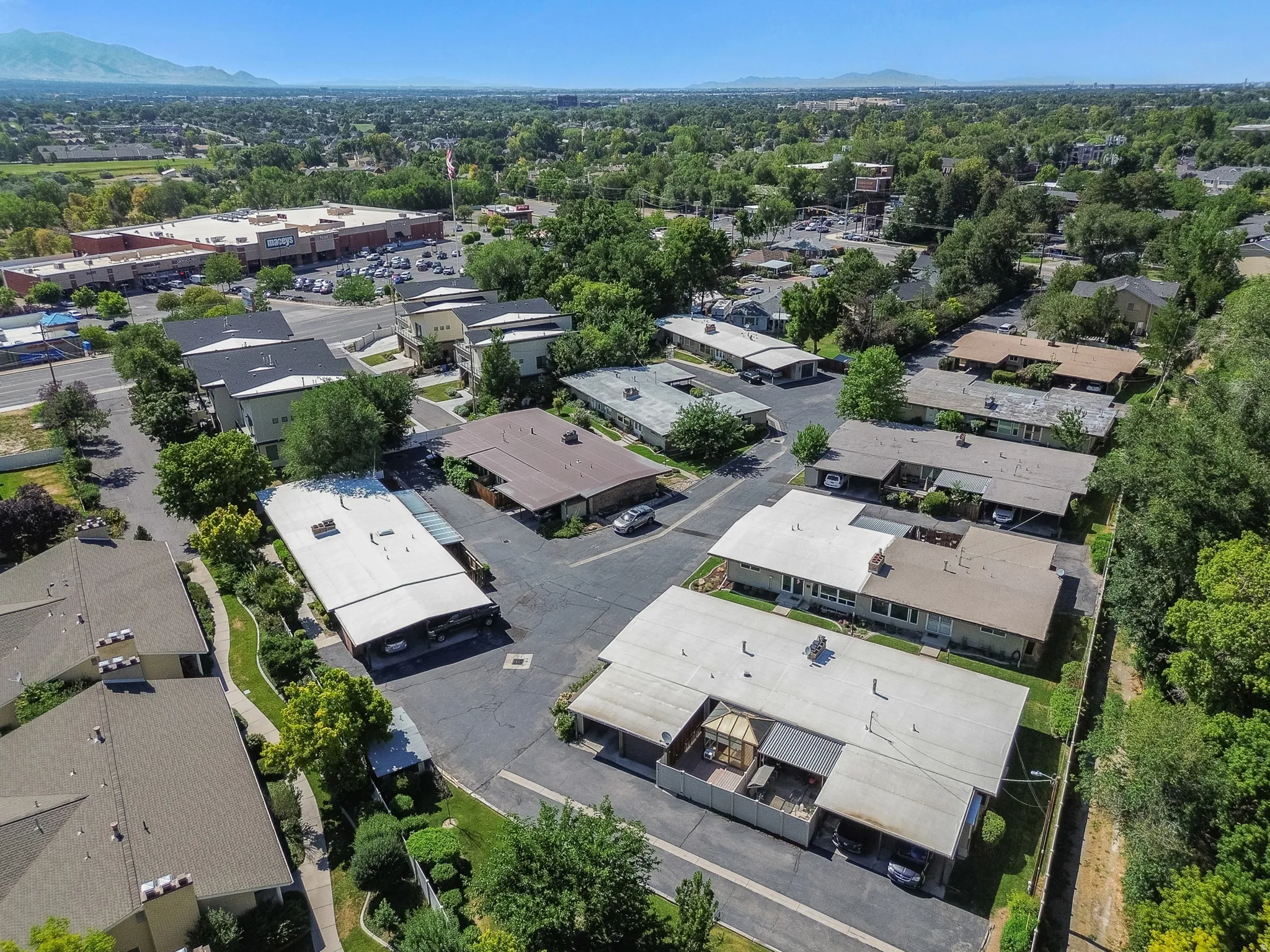 Aerial perspective showcasing multiple residential buildings with varied rooflines and surrounding green spaces