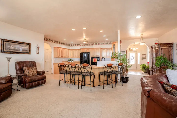 Kitchen featuring wood cabinetry, an integrated breakfast bar, recessed lighting, and a black appliance suite