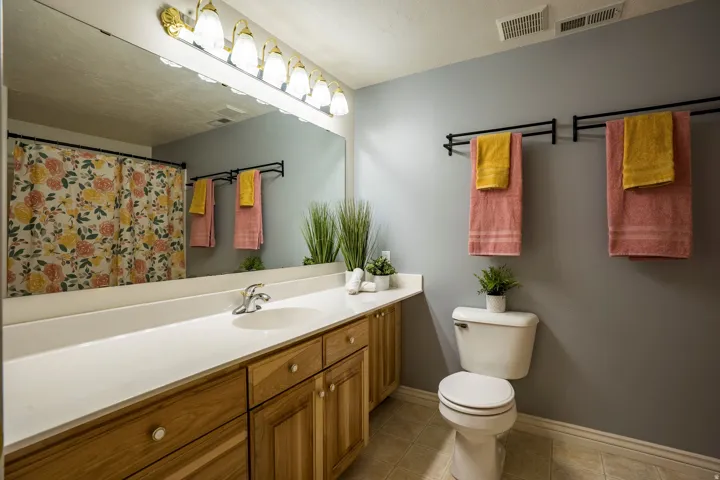 Bathroom featuring an extended vanity with a white countertop and wood-finish cabinetry