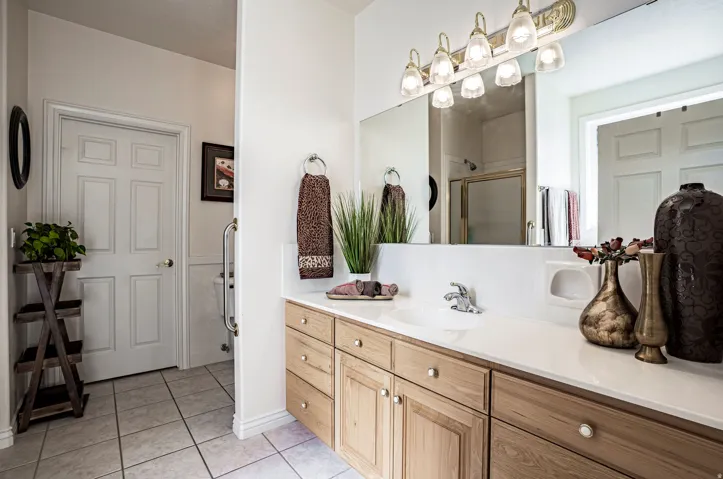 Ensuite Bathroom vanity featuring a light wood-finish cabinet, white countertop, and integrated sink