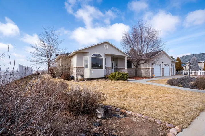 Contemporary ranch-style residence featuring a prominent arched window and a two-car attached garage