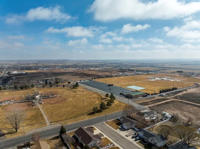 Aerial perspective showcasing extensive sports fields, including multiple baseball diamonds and a rectangular court