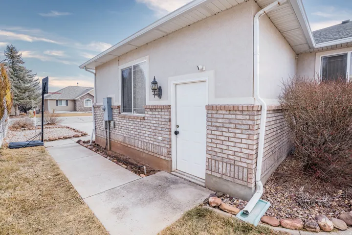 Stucco exterior with a light-colored brick foundation