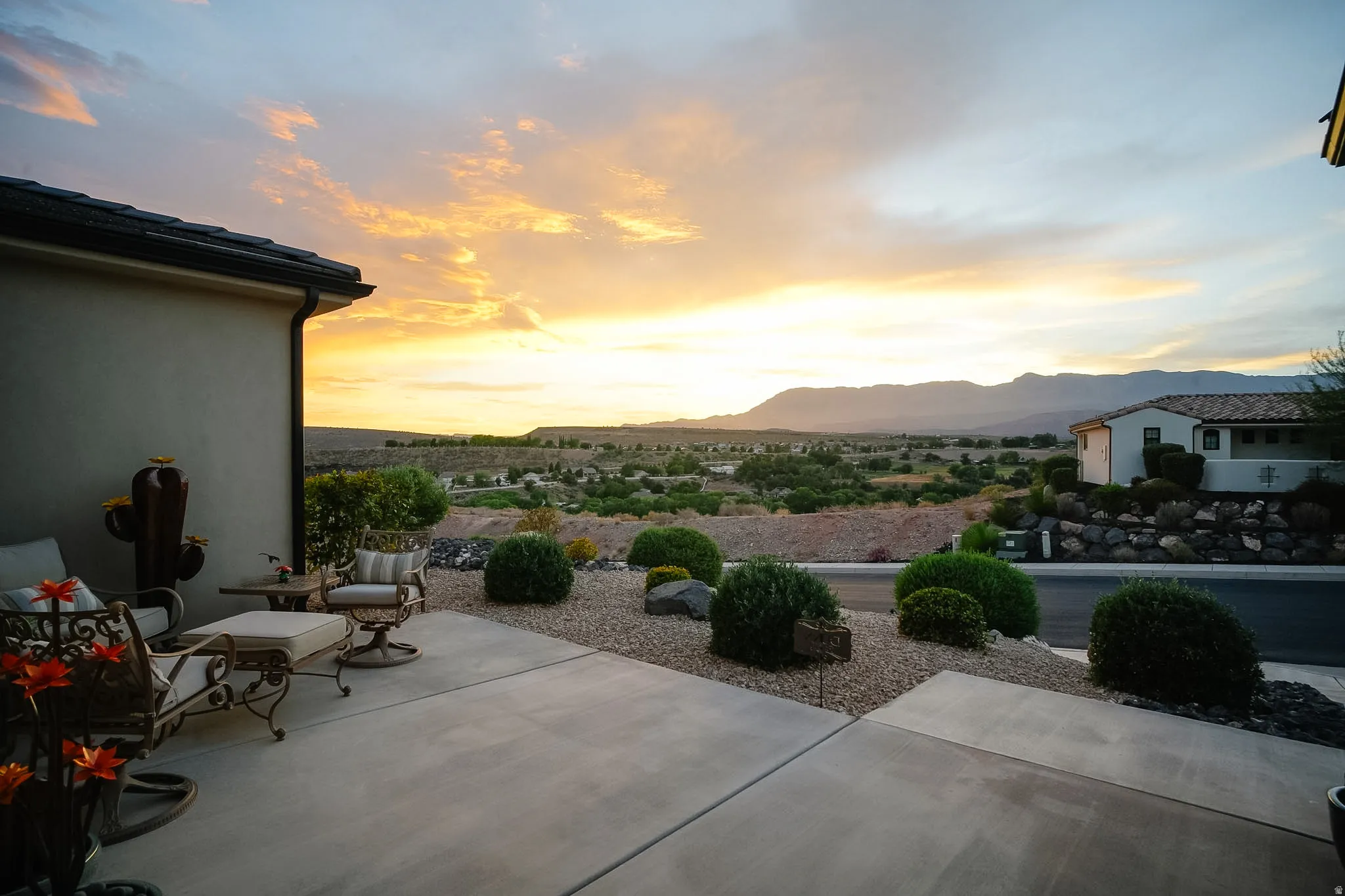 Expansive outdoor patio with concrete paving and gravel landscaping