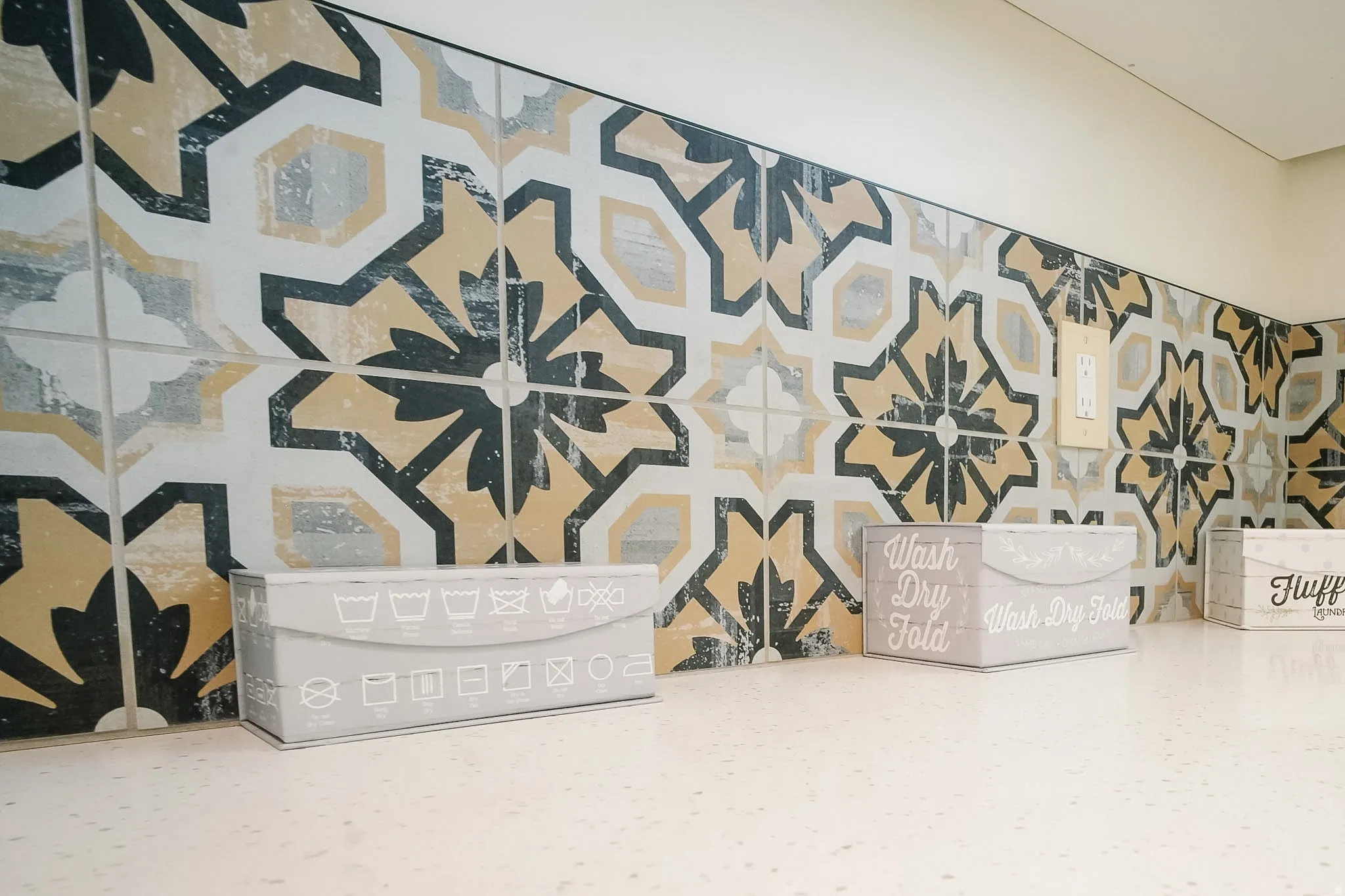 Decorative tile backsplash featuring a geometric pattern in black, white, and gold tones