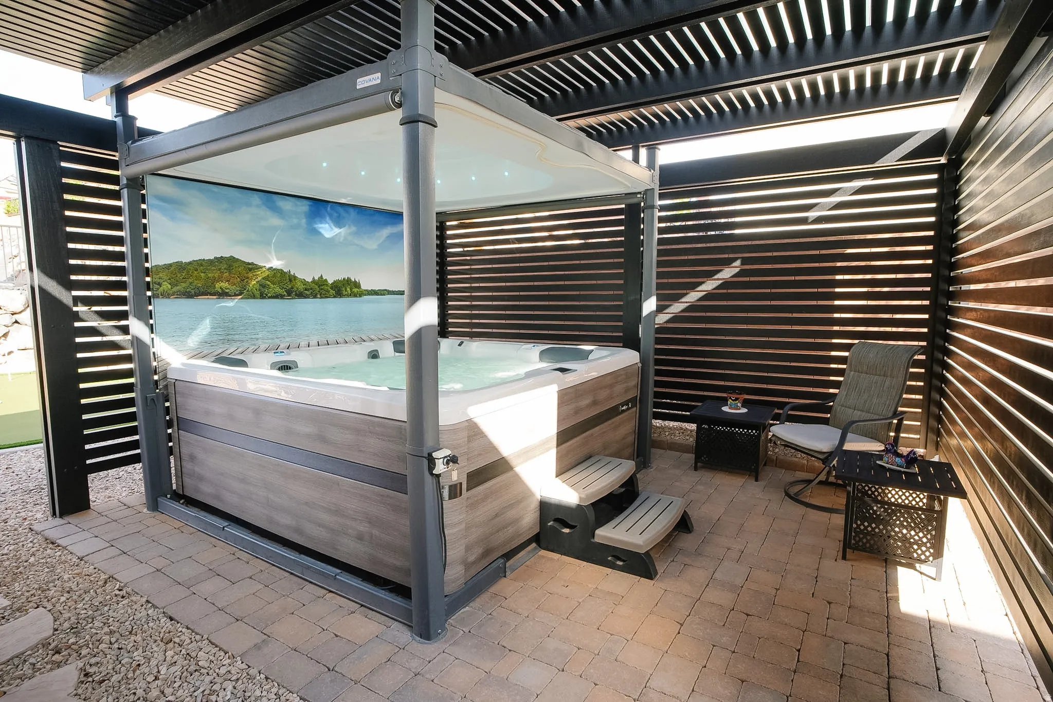 Outdoor spa enclosure featuring an adjustable louvered roof and privacy screen panels
