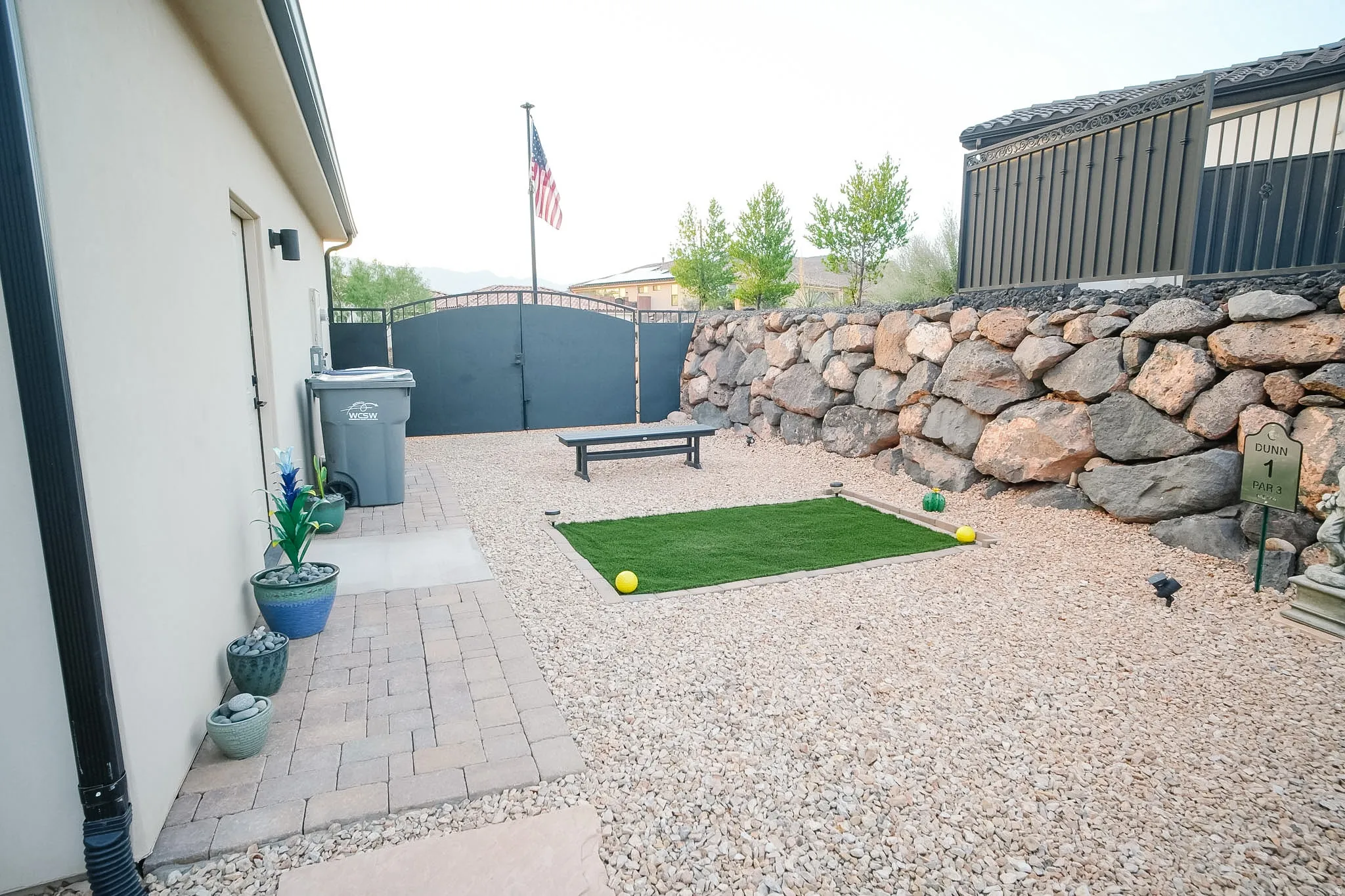 Exterior space featuring pea gravel landscaping and a prominent stone retaining wall