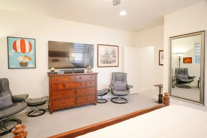 Recessed lighting illuminates neutral walls and light gray carpet