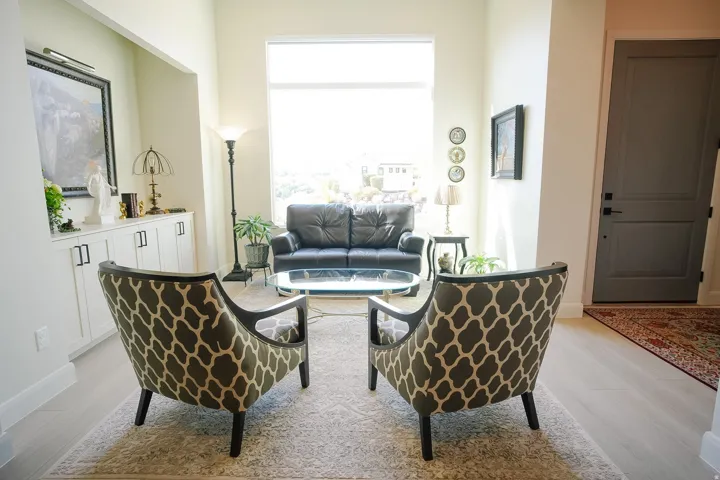 Bright living space featuring a large picture window, light wood-finish flooring, and built-in cabinetry with dark hardware