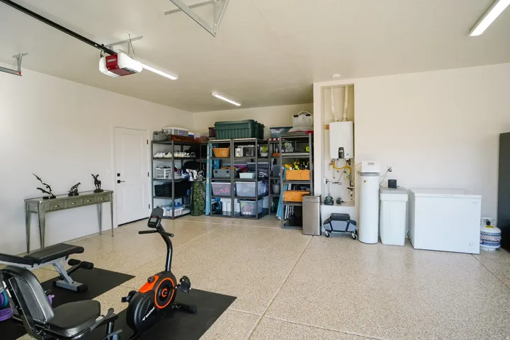 Epoxy-coated flooring, white walls, overhead lighting, and an automatic garage door opener