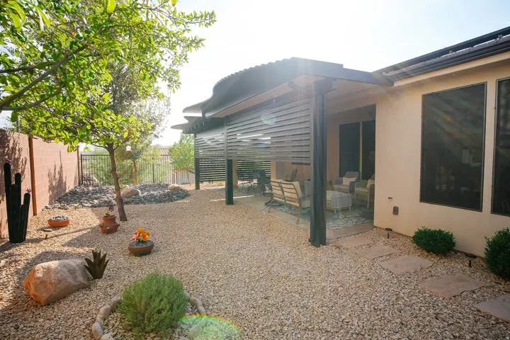 Expansive gravel landscaping featuring mature trees and desert vegetation