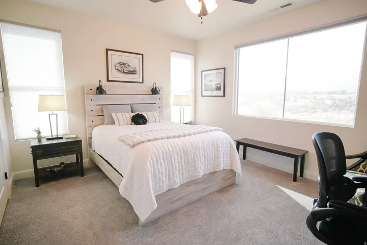 Bedroom featuring light-toned walls and plush gray carpeting