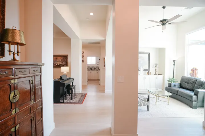 Light-toned flooring extends throughout the open-concept interior, featuring high ceilings and recessed lighting