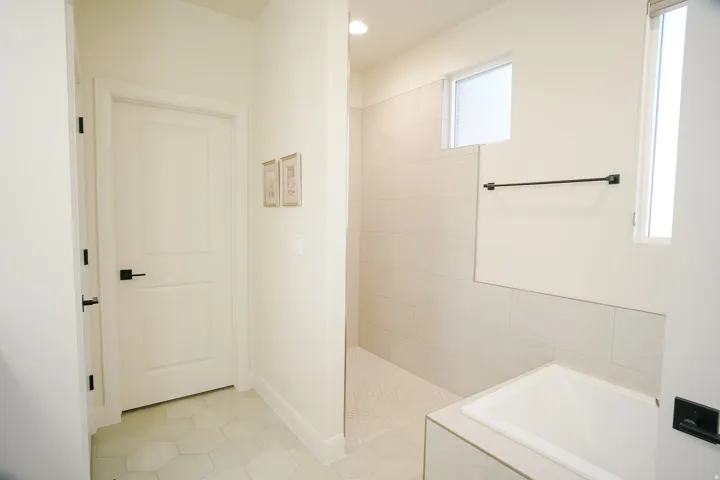 Bathroom featuring a built-in soaking tub, walk-in shower with tiled walls and floor, and hexagon tile flooring