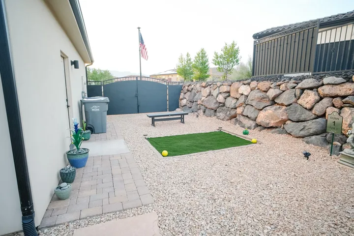 Exterior space featuring pea gravel landscaping and a prominent stone retaining wall