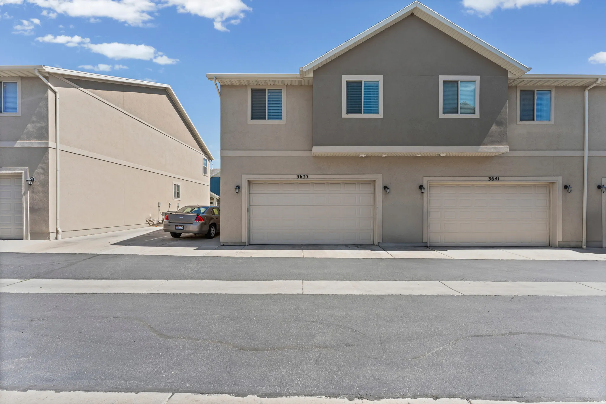 Multi-level townhome exterior featuring an attached two-car garage with individual doors