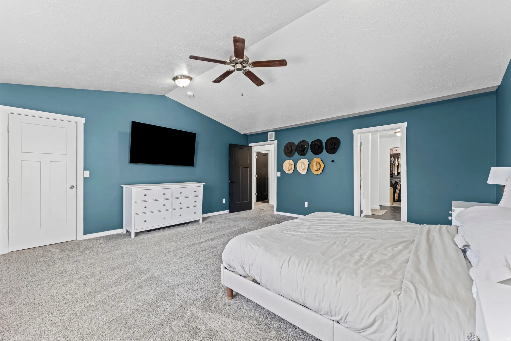 Spacious room featuring vaulted ceilings, a ceiling fan, recessed lighting, and soft carpet flooring
