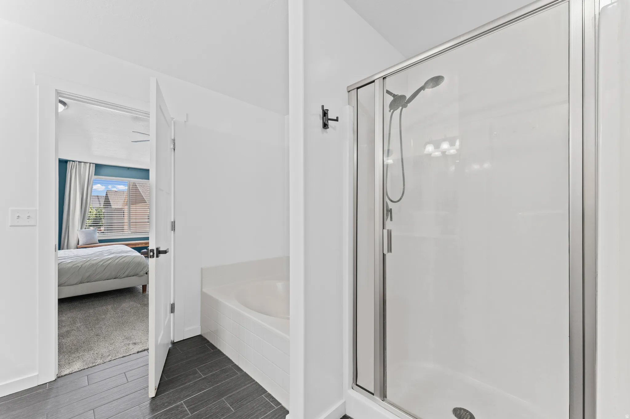 Shower enclosure with a glass door and an adjacent built-in soaking tub