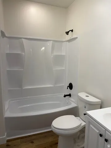Bathroom featuring a white bathtub and shower surround with integrated shelving