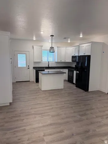 Modern kitchen with white cabinetry and black countertops