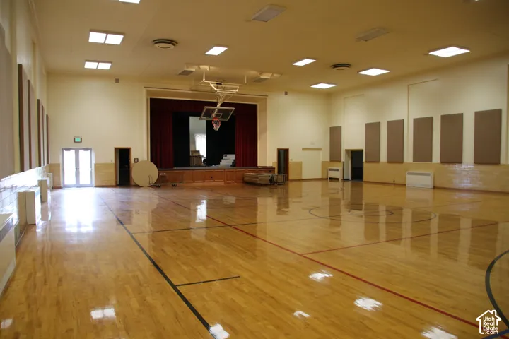 Large recreational hall featuring polished wood-finish flooring with court markings