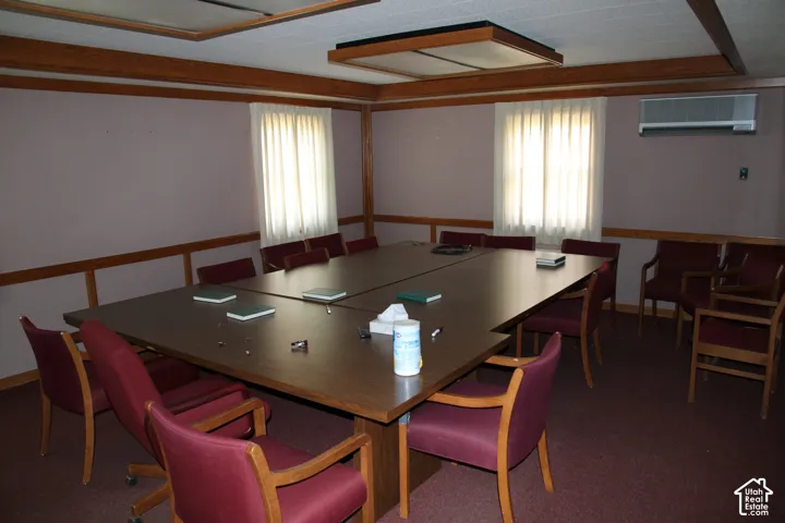 Spacious room featuring wood-finish paneling and an integrated drop ceiling with recessed lighting