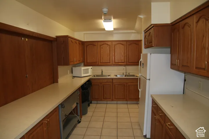 Kitchen featuring ample wood cabinetry, a dual-basin stainless steel sink, and extensive countertop space