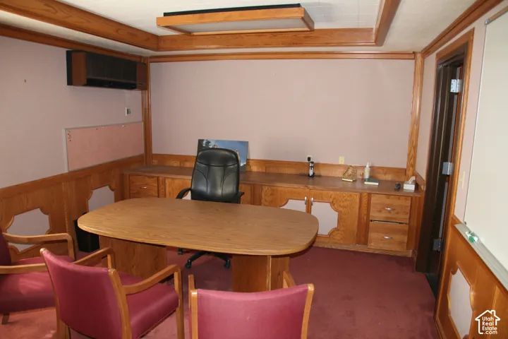 Room featuring wood paneling, wood-finish built-in cabinetry, and a ceiling-mounted lighting fixture