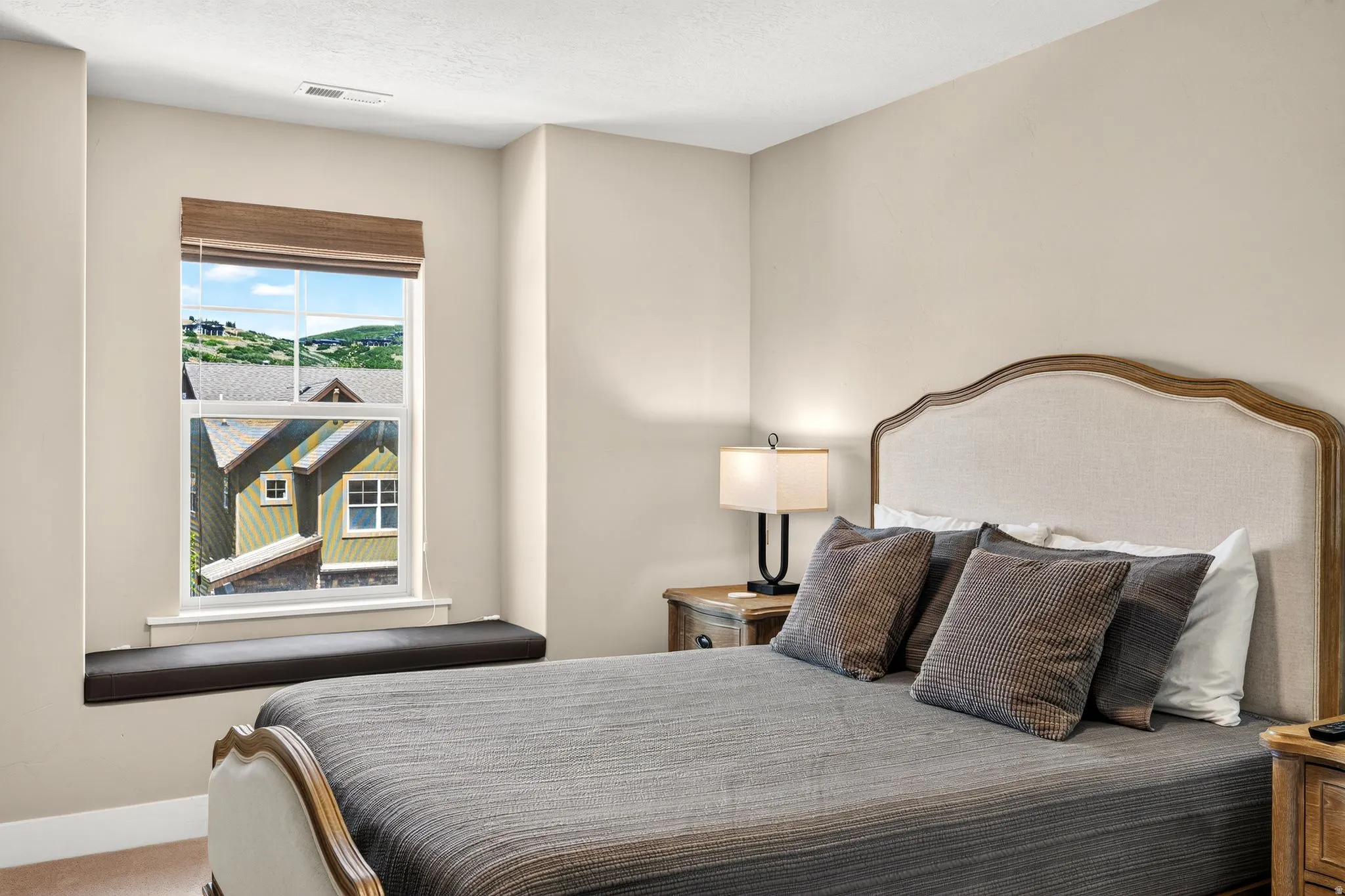 Bedroom featuring a window seat, neutral wall tones, and plush carpeting