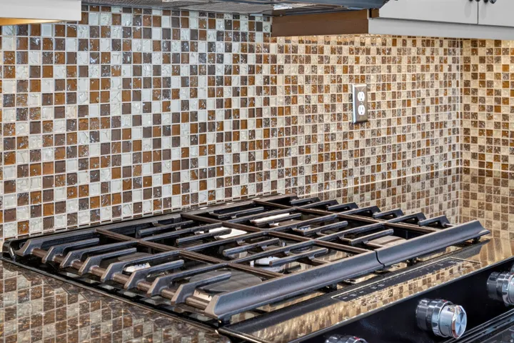 Integrated gas cooktop featuring five burners and coordinating metal grates