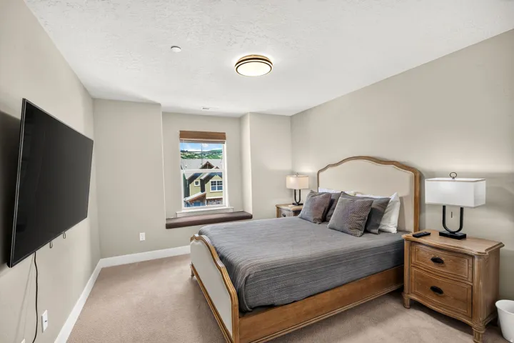 Bedroom featuring textured neutral carpeting and light-toned wall paint