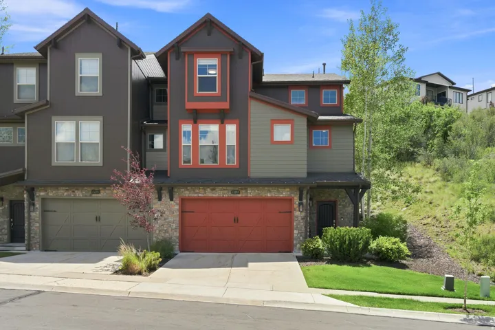 Contemporary townhome exterior with mixed material facade, featuring stone accents and horizontal siding