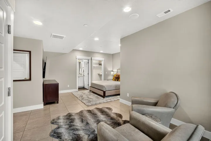 Tiled flooring extends through this open concept space, featuring recessed ceiling lighting, light gray wall tones, and white baseboards