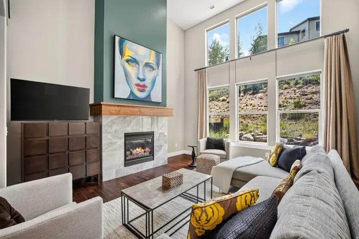 Living area featuring a gas fireplace with a light-toned stone surround and a substantial wood mantel