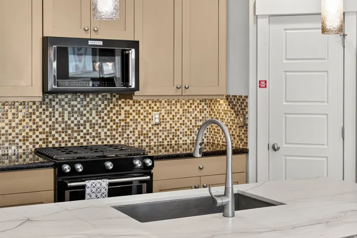 Kitchen island with a built-in undermount sink and a gooseneck pull-down faucet