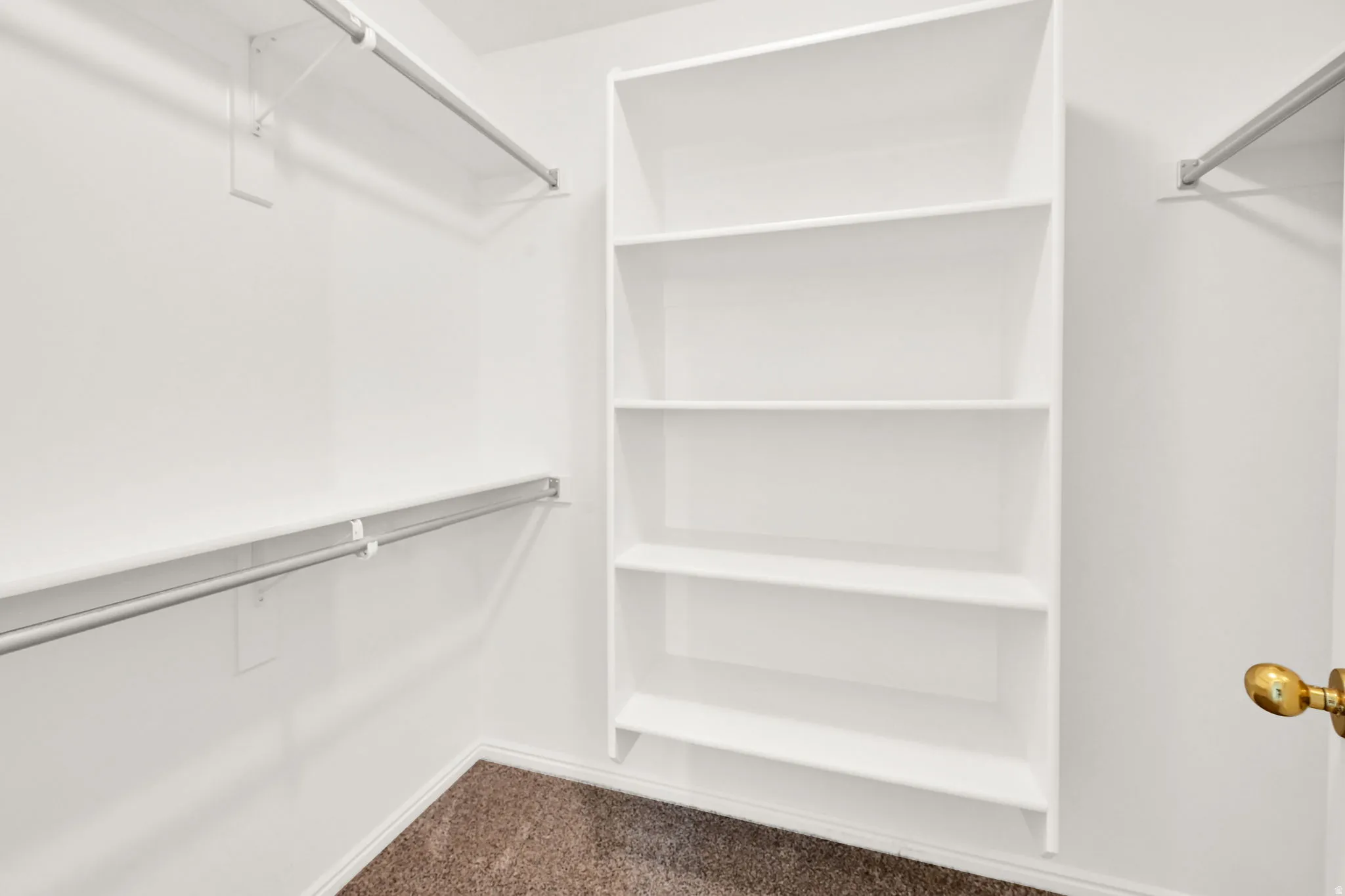 Walk-in closet featuring built-in shelving and dual hanging rods
