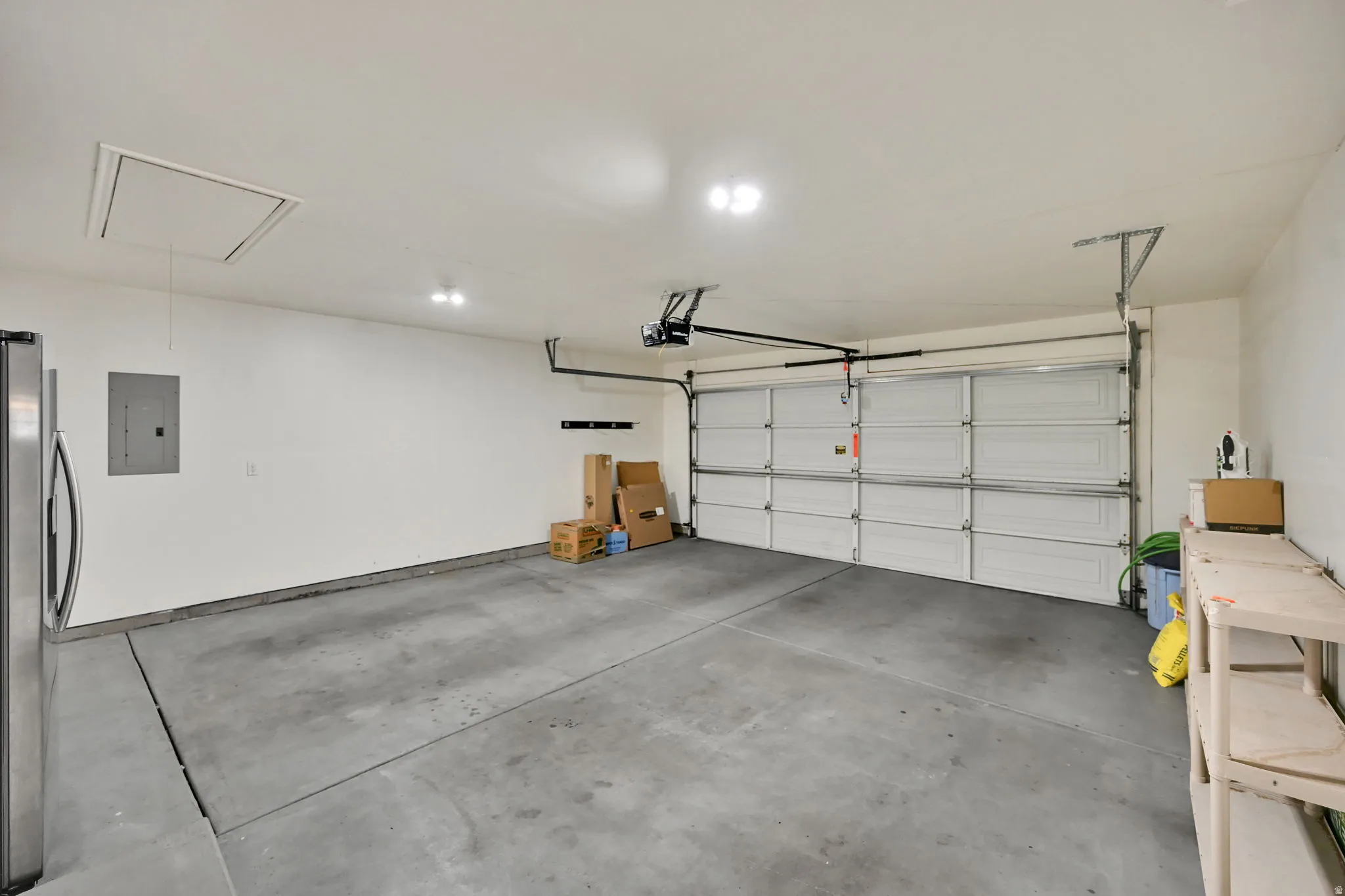 Attached garage space with 2nd refrigerator and shelving