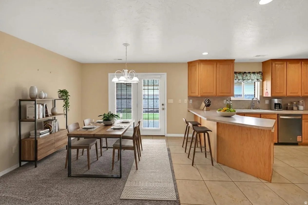 Virtually staged open concept kitchen and dining area featuring  a breakfast bar, NEW stainless steel appliances, and tile flooring