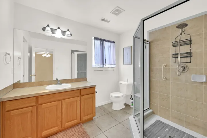 Full bathroom featuring a walk-in shower with tile surround and single vanity