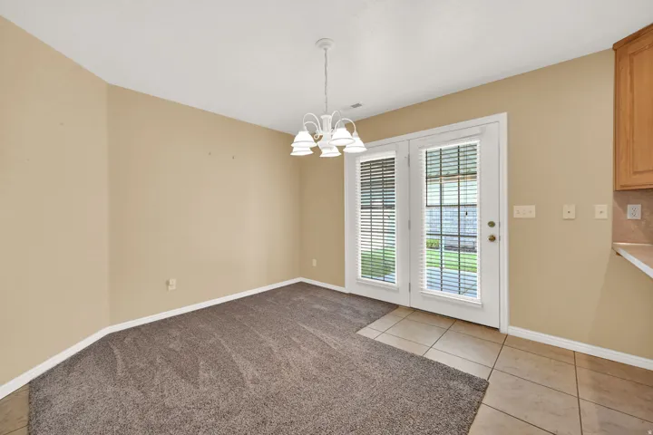 Dining area featuring dual French doors with integrated blinds