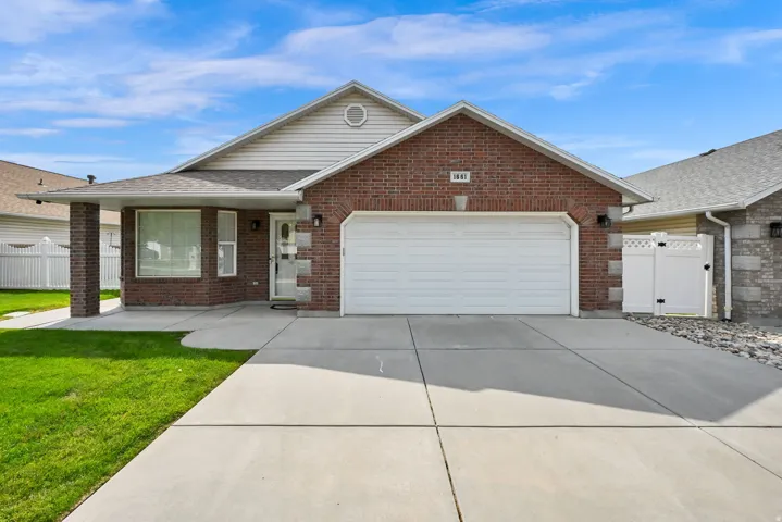 Brick and siding exterior featuring an attached garage and covered entry