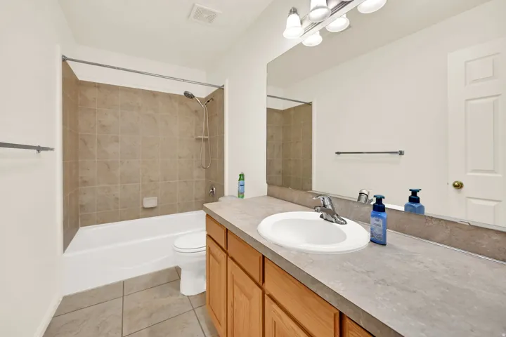 Full bathroom featuring a white porcelain tub and tile surround