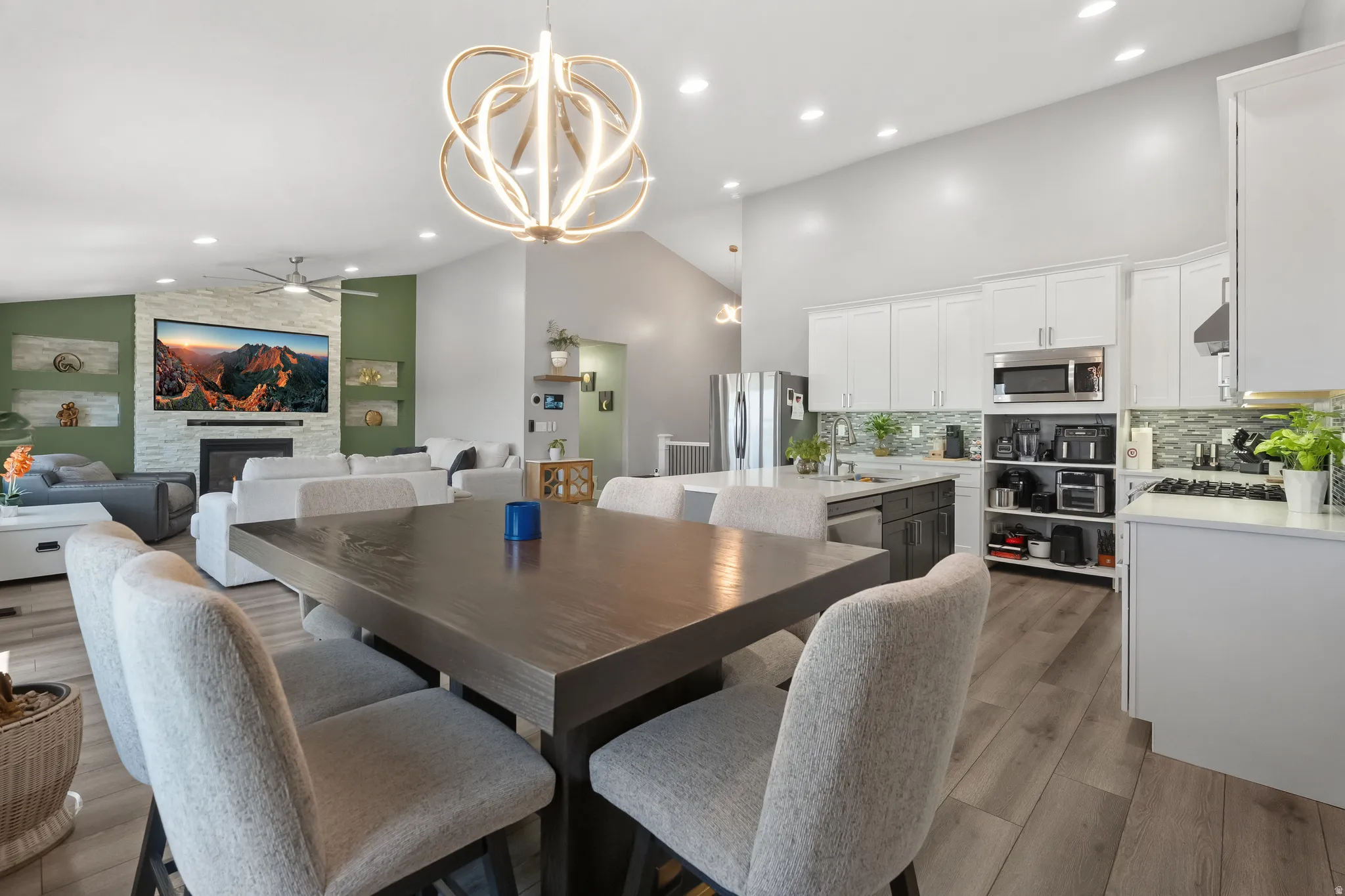 Spacious open-concept living area featuring wood-finish flooring and vaulted ceilings
