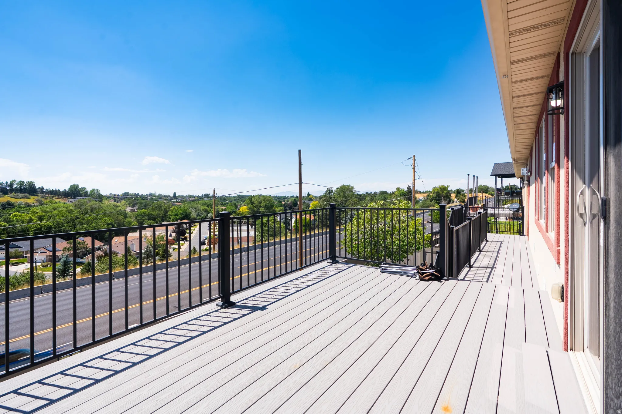 Outdoor deck with light-colored composite decking and a black metal railing