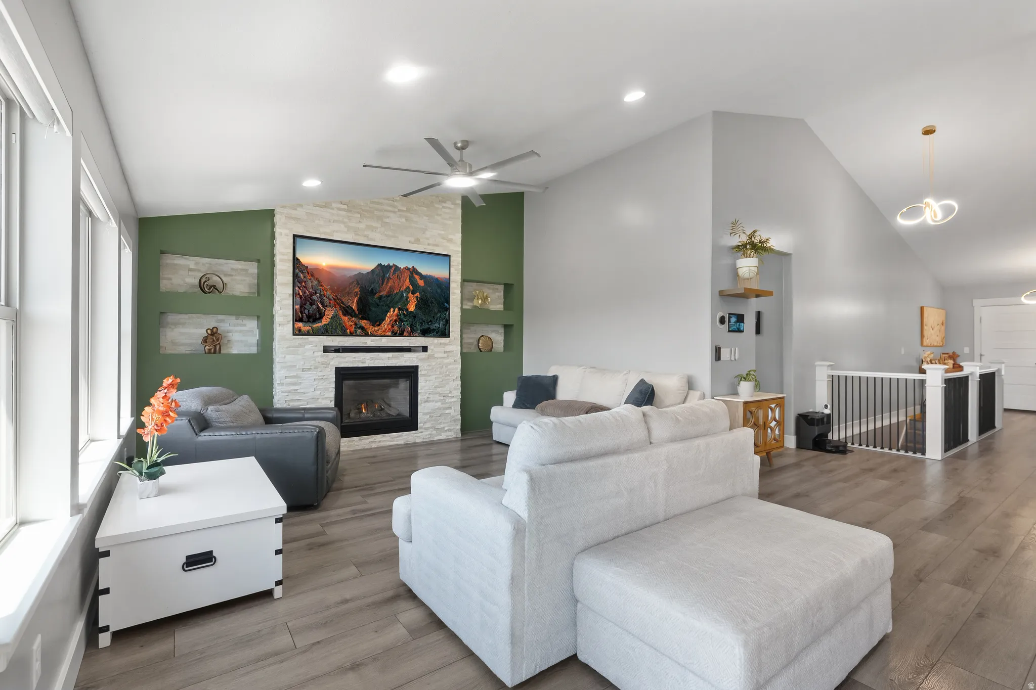 Spacious living area featuring vaulted ceilings and wood-finish flooring