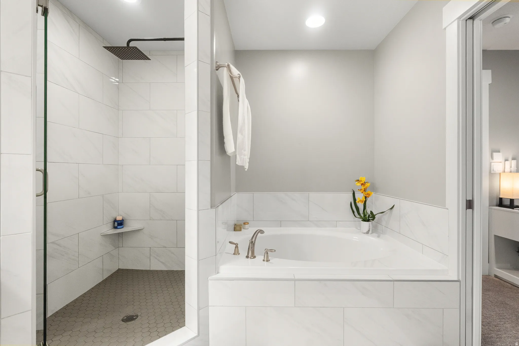 Contemporary bathroom featuring a large soaking tub with tile surround, a spacious walk-in shower with a glass enclosure, and a rain showerhead